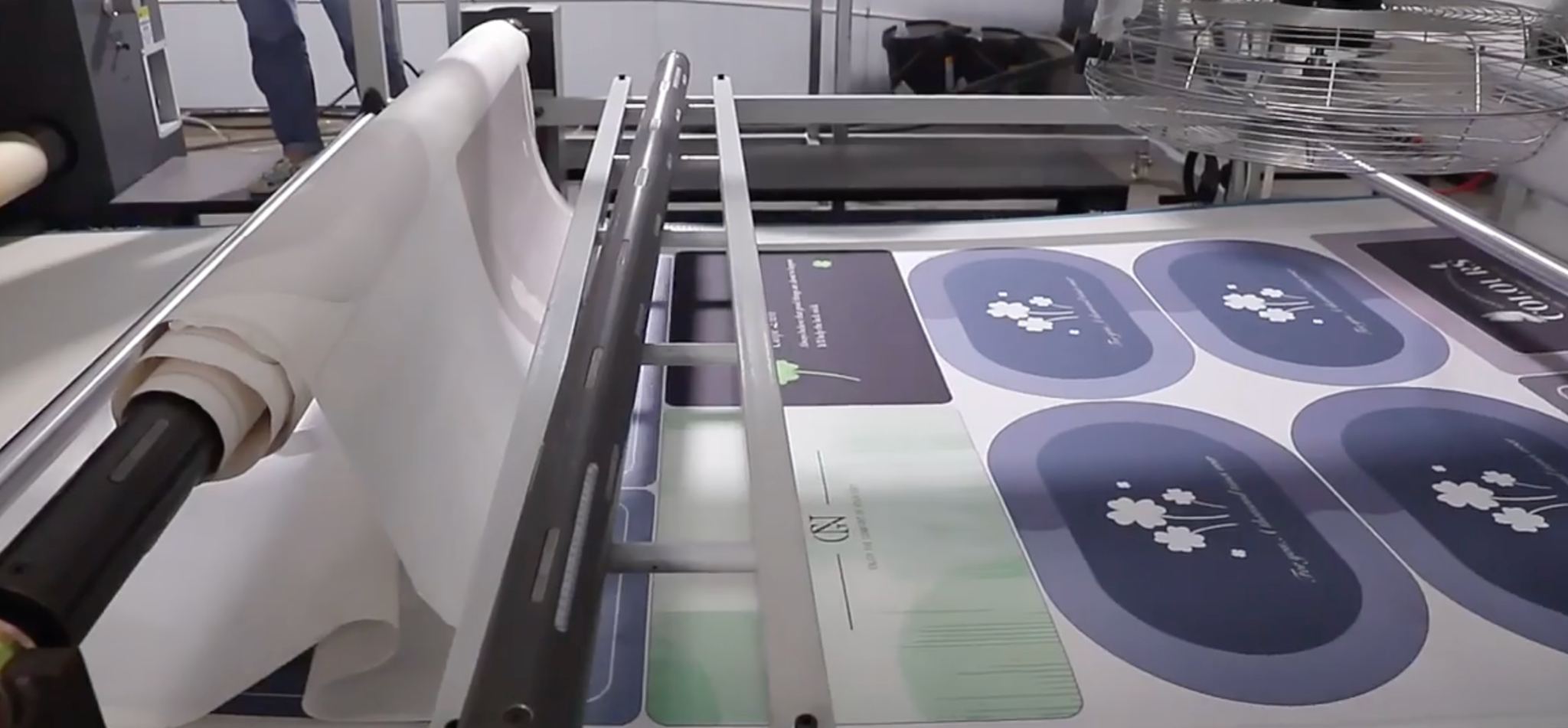 Printed soft mat material moving through production equipment